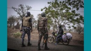 Le 26 mars 2022, à un point de contrôle en périphérie de Porga, au Bénin, un motocycliste est appréhendé par un soldat et un policier béninois.
